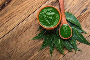 Medicinal Neem leaves with paste on wooden background