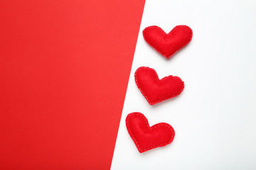 Red fabric hearts on colorful paper background