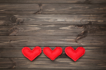 Red fabric hearts on brown wooden table