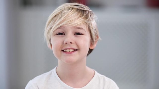 portrait of cute young blonde boy, smiling kid