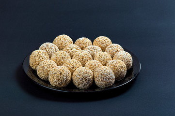 Amaranth ladoo or Rajgira laddu or Cholai ke laddo in black plate on black background.