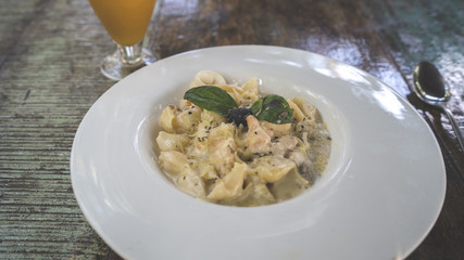 A dish of the Carbonara paste with seafood in a big white plate.