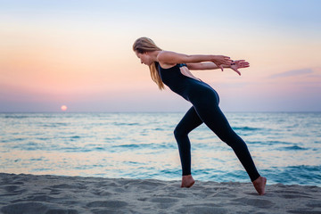 Caucasian woman practicing yoga at seashore
