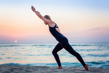 Caucasian woman practicing yoga at seashore