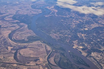 Fototapeta na wymiar Mississippi River aerial landscape views from airplane over the border of Arkansas and Mississippi. Winding river and Rural town and cities, United States of America. USA.