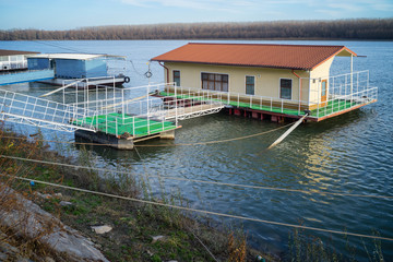 Floating house on the Danube river built on a pontoon linked to the docks and water front by metal...