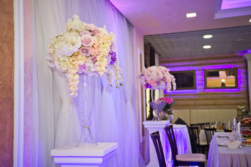 Decorative bouquets of flowers in vases as decoration of the wedding tab