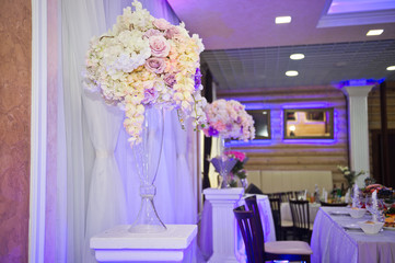 Decorative bouquets of flowers in vases as decoration of the wedding tab