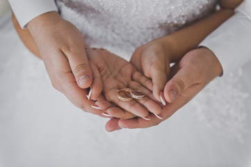 The gentle embrace of the newlyweds with wedding rings 2299.