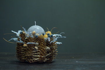 Close-up of winter decor with grey candle on a wooden surface, selective focus