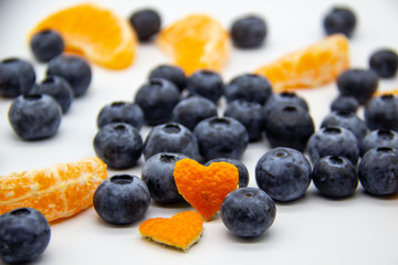 Fresh blueberry  with mandarin slices on white background. A composition of the blueberries and mandarin pieces which is organic and healthy. The berries and fruit full of vitamins.