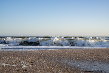 Sea waves, beach, clear sky on a sunny winter day.