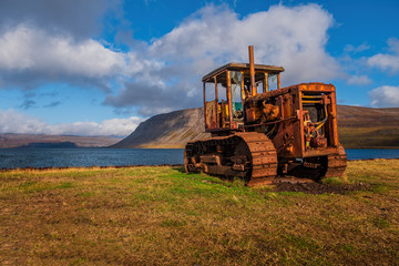 Fototapeta premium old broken bulldozer(tractor) in Icelandic Arnarfjordur. Iceland, september 2019. Beautiful sunny day.