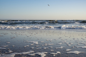 Sea waves, beach, clear sky on a sunny winter day.