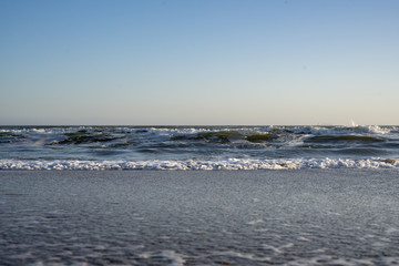 Sea waves, beach, clear sky on a sunny winter day.