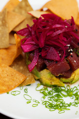 Top close up of tuna tartar with avocado and tortilla chips