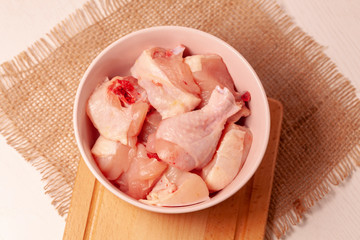 raw chicken in bowl on jute cloth background