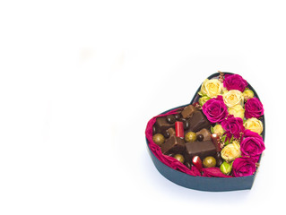 heart shaped gift box with candy and flowers inside on white