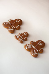 Delicious homemade gingerbread men. Fresh cookies family on white background. New year decorations. Flatlay style.