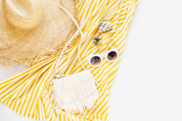 Yellow dress with stripes with straw hat, sunglass, and white handbag. Women's stylish summer...