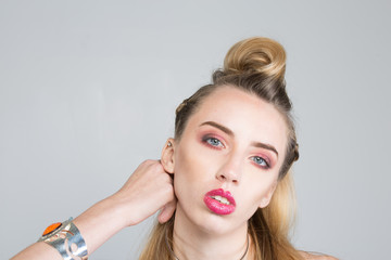 Vintage style image of blonde fashion model with full makeup and hair.