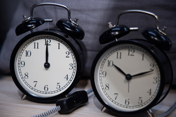 Retro clock on wooden texture front dark blue wall background. Vintage effect.