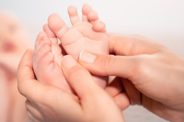 Obraz na płótnie Canvas newborn baby feet on female hands
