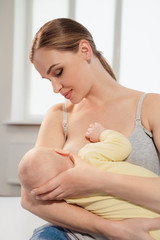 mother breastfeeding baby at home. Breastfeeding mother with little child