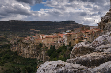 Fototapeta na wymiar Landscape of the town of Cantavieja with its houses on the edge of the precipice and the Church of the Assumption and its dome on the right on a cloudy day, Cantavieja, Teruel, Spain