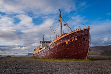An out-of-the-way whaling ship that rusts on the road to Latrabjarg on a dead cloudy day. The...