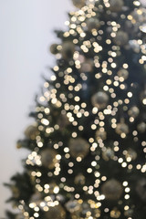 Vertical view of blurred christmas tree with garlands.