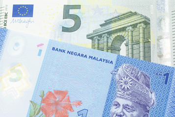 A blue, one ringgit Malaysian note close up in macro with a five Euro note from the European Central Bank