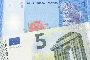 A blue, one ringgit Malaysian note close up in macro with a five Euro note from the European Central Bank