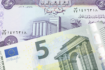 A purple fifty dinar note from Iraq close up with a five Euro note from the European Central Bank
