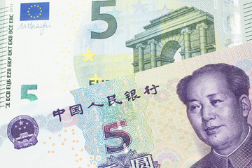 A close up image of a five euro note from the European Union euro zone along with a one yuan bank note from the People's Republic of China