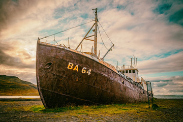 An out-of-the-way whaling ship that rusts on the road to Latrabjarg on a dead cloudy day. The...