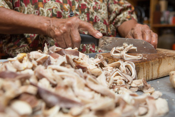Selective focus of cook is cutting the boiled pork  on the cutting board