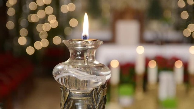 Cardinal and priest in front of the altar in catholic church. Lit candle. Christmas Midnight mass in Cathedral. Christianity and religion.   