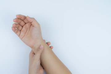 Closeup woman holds her wrist pain on white background. Health care and medical concept.
