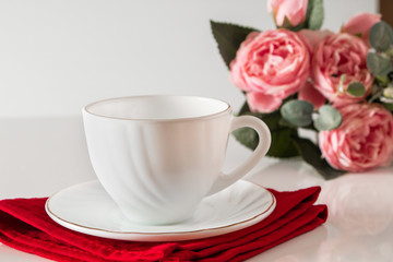 Obraz na płótnie Canvas White cup for coffee on a red napkin
