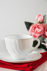 Fototapeta na wymiar White cup for coffee on a red napkin