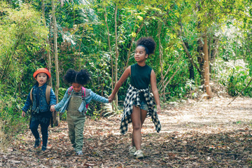 diverse people of african american children having fun walking together in forest
