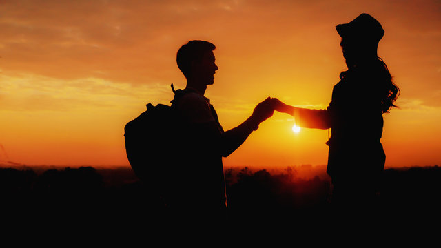 silhouette of loving couple having romantic moment during travel together with sunset sky