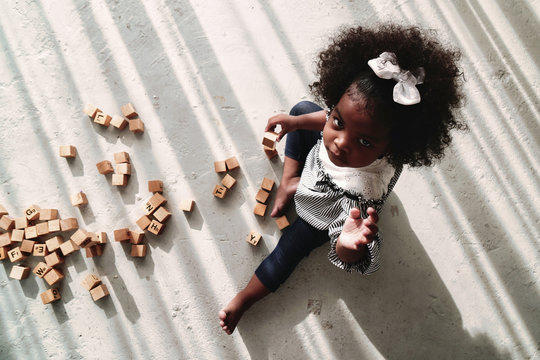 African American Girl Child Playing Letter Block On Floor