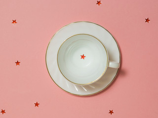 A white empty coffee Cup with red stars on a pink background.