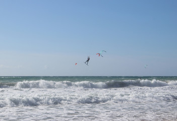 Jumping kitesurfer with blue sky