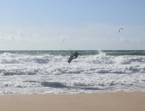 Jumping kitesurfer with blue sky