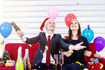 Happy new year 2020 concept,Happy couple lighting paper fireworks With champagne and cookies on the table in Christmas and New Year's Eve party After finishing business work.