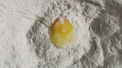  Cracking egg in flour macro shot, cooking process close up, making a dough, isolated, slow motion, shot on Red Weapon Helium 8k