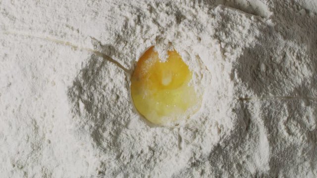  Cracking egg in flour macro shot, cooking process close up, making a dough, isolated, slow motion, shot on Red Weapon Helium 8k